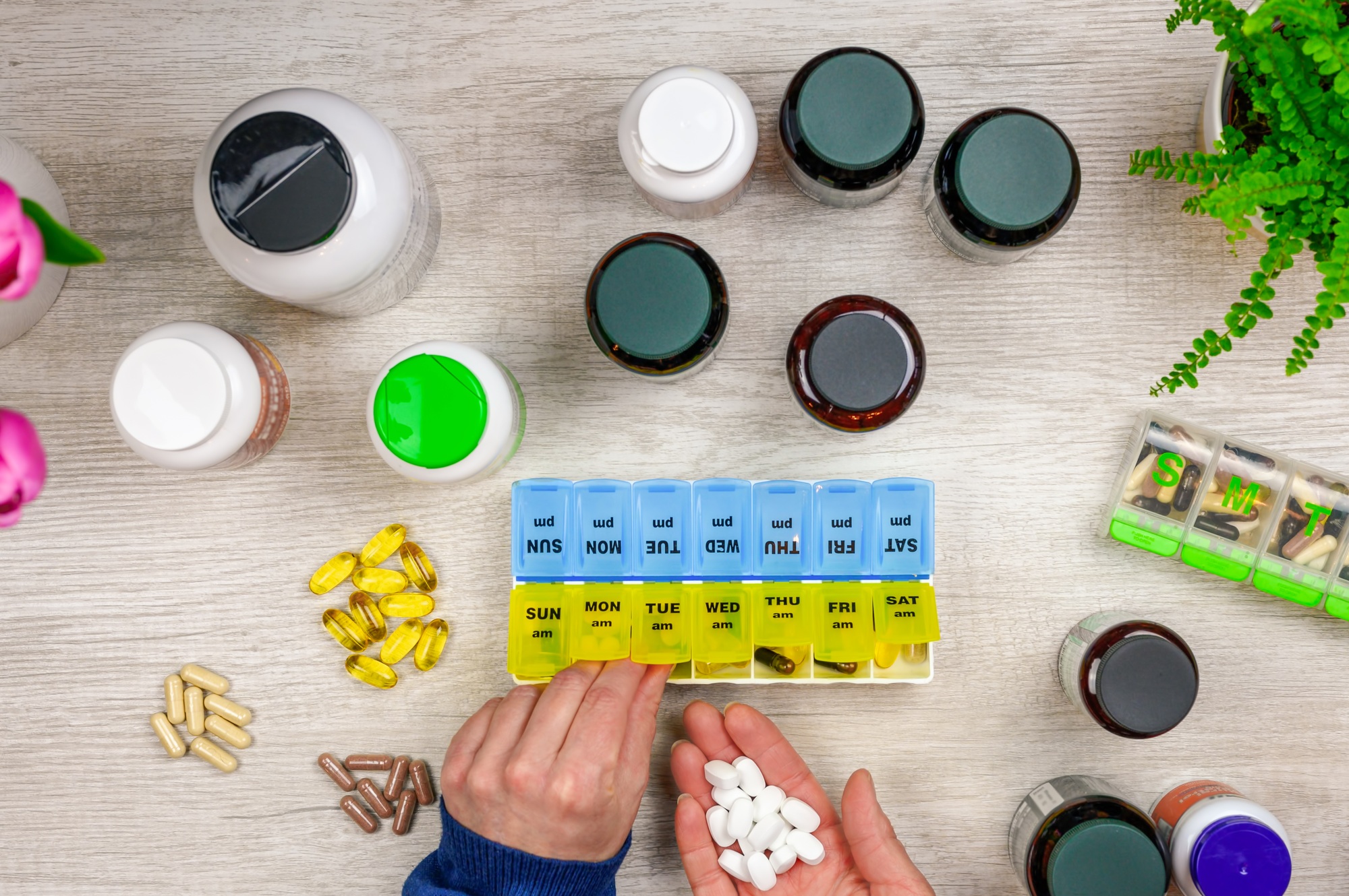 Woman filling pill organizer with vitamins and supplements
